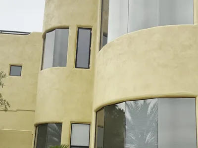 Curved stucco elevations of Fountain Hills AZ custom home masked for spraying and after fresh gold exterior paint
